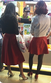 夜幕时分站在冷饮店前面排队等候的两个红裙女郎，银色高跟实在漂亮