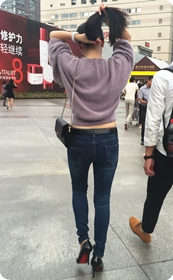 逛街途中玩弄头发蛮腰小露的牛仔长裤美眉，尖头亮皮高跟很漂亮