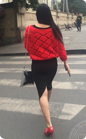 站在路口等车的红色镂空毛衣黑色开叉裙女郎