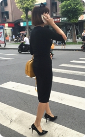 路口身材高挑的黑色紧身裙摩登女郎：完美的曲线，漂亮的黑高