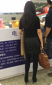 机场航站楼准备办理电瓶车服务的PU裙黑袜高跟少妇